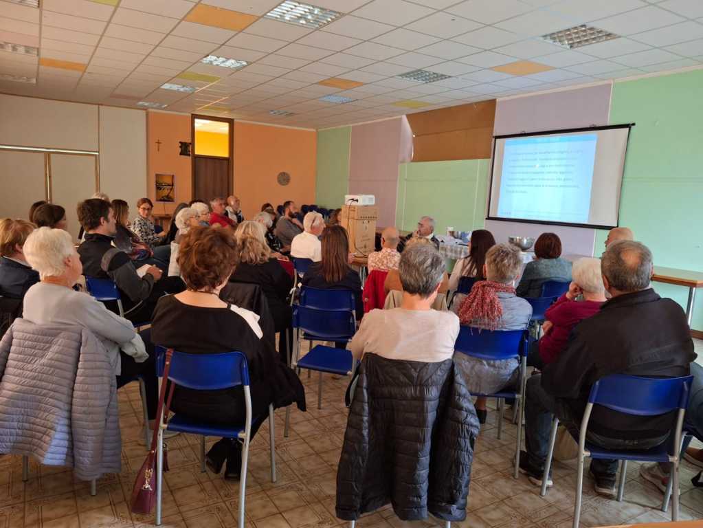 Palco illuminato con persone che recitano davanti a un pubblico