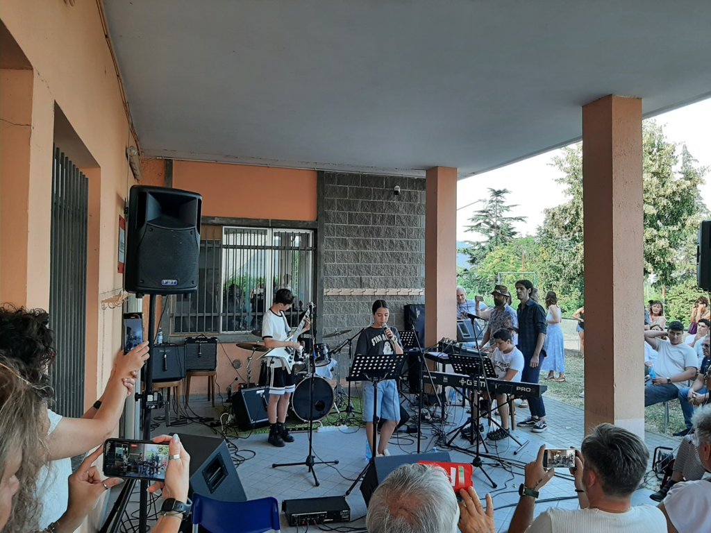 Gruppo di persone che canta insieme con i fogli in mano