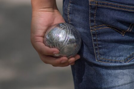 Gruppo di persone adulte e anziane che sorridono sedute vicino a un campo da gioco